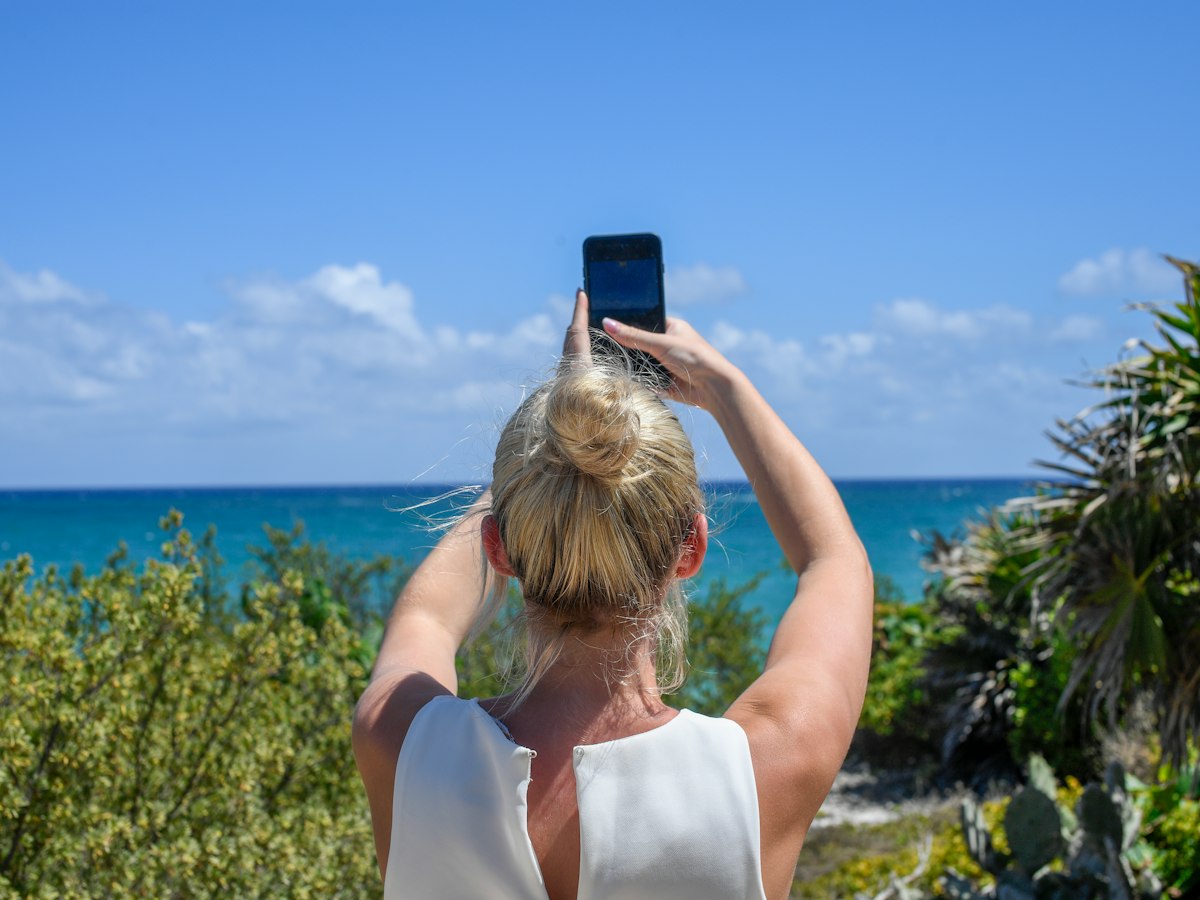 A guest photographing the ocean view with her phone